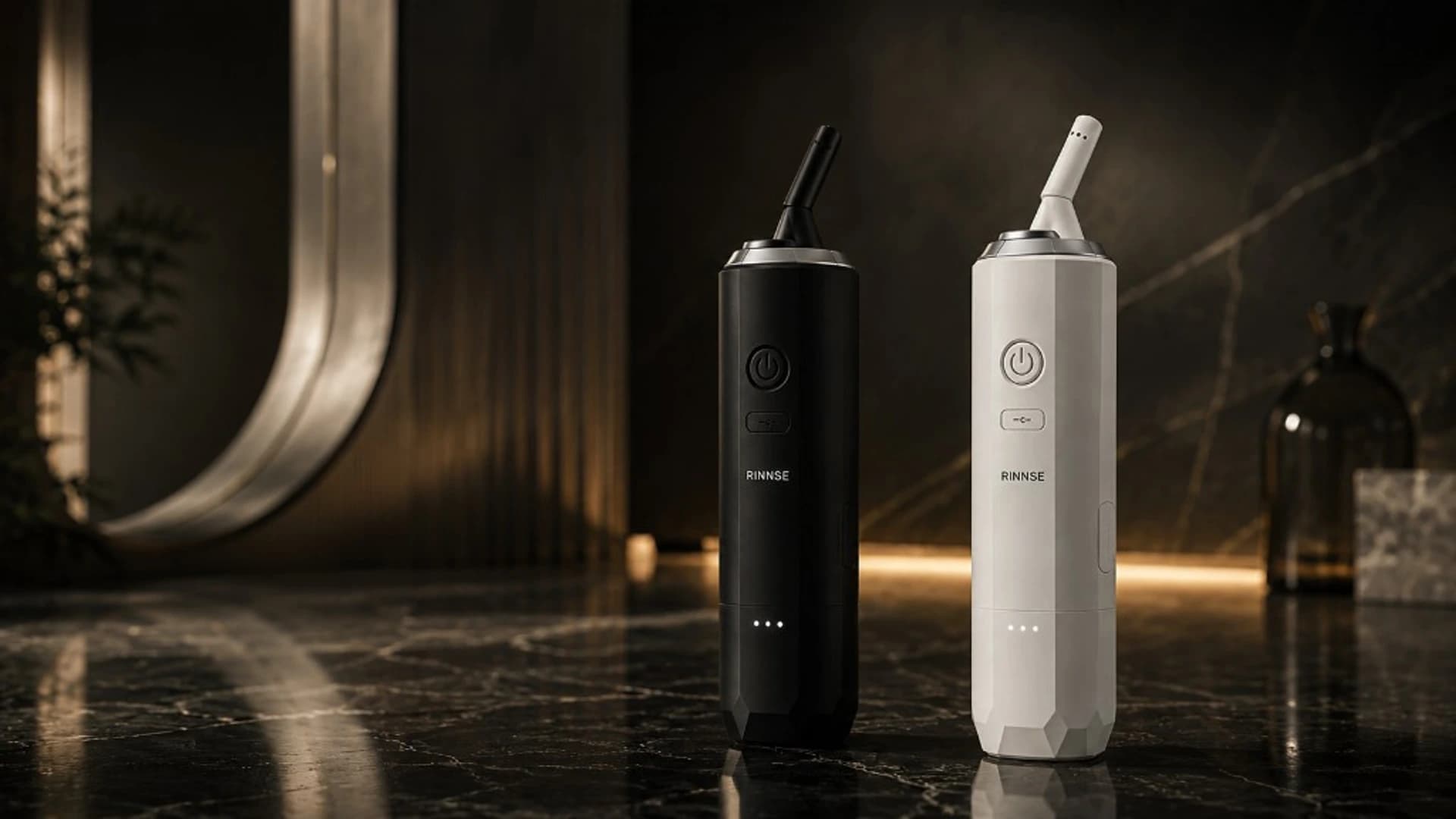 RINNSE bærbar elektrisk bidet i Noir og Off White på marmor — premium hero med dansk wellness-design